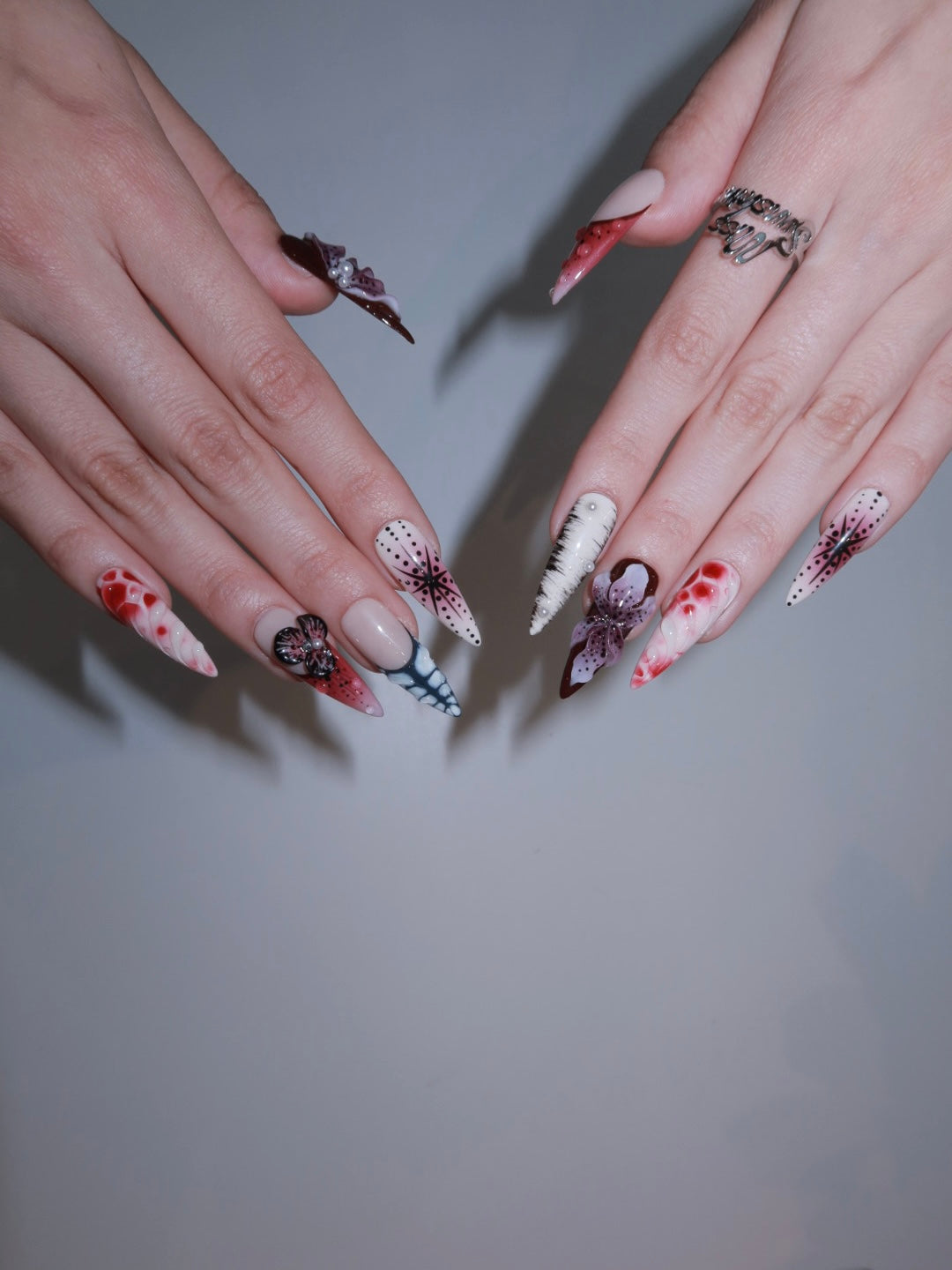 Jungle-inspired red nail art with bold patterns and shine