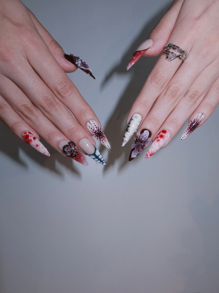 Jungle-inspired red nail art with bold patterns and shine