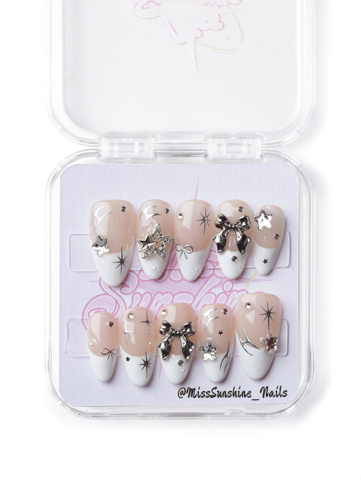 Elegant short almond press-on nails featuring silver accents, French tips, and coquette-inspired details