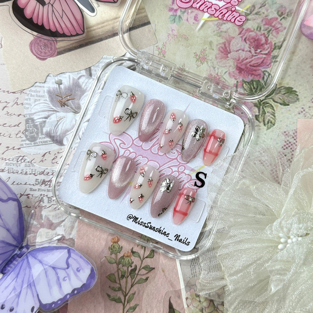Short almond nails with strawberry and bow design