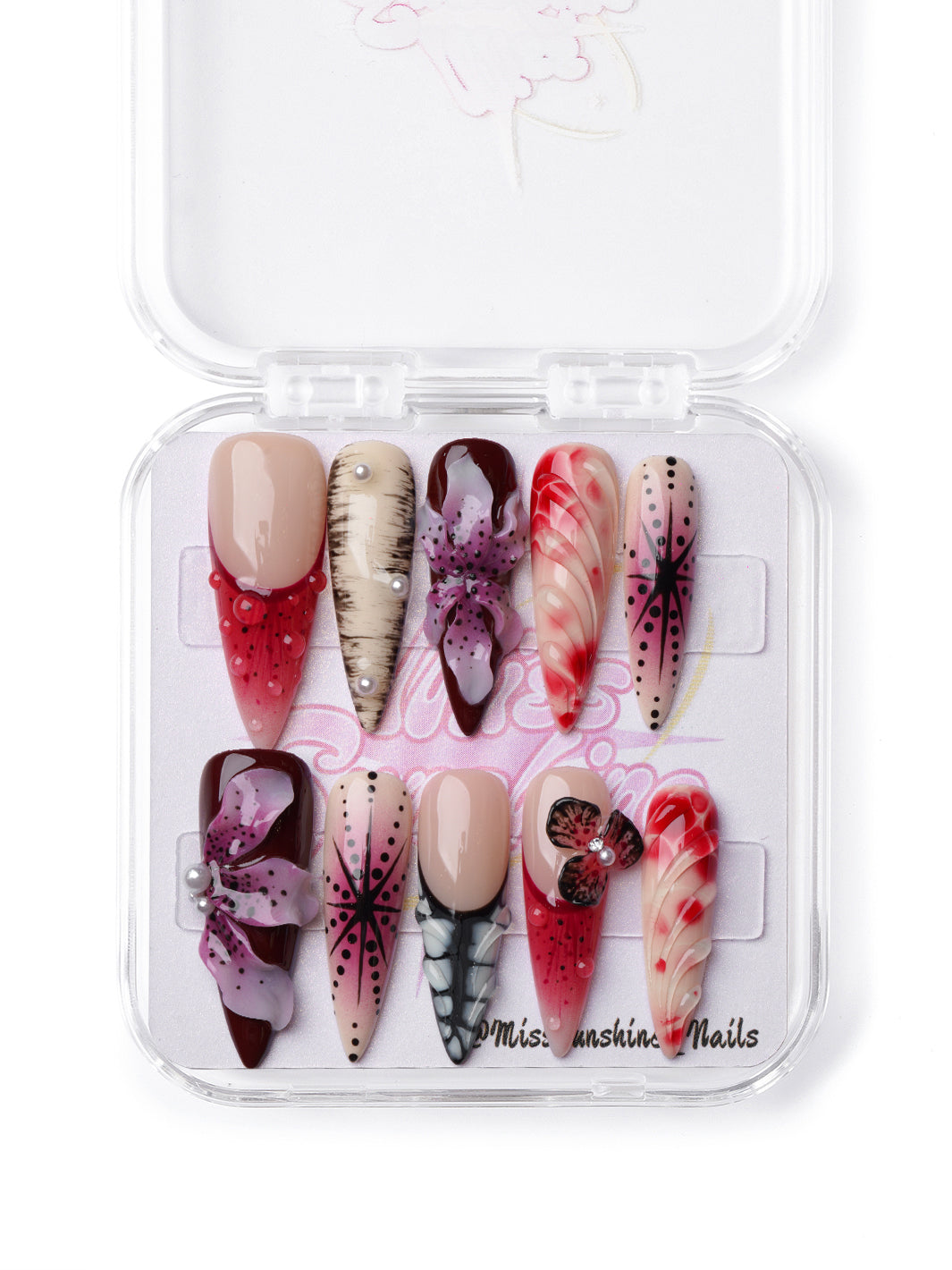 Exotic-inspired press-on nails in long stiletto shape with detailed florals, dotwork, and wild patterns.
