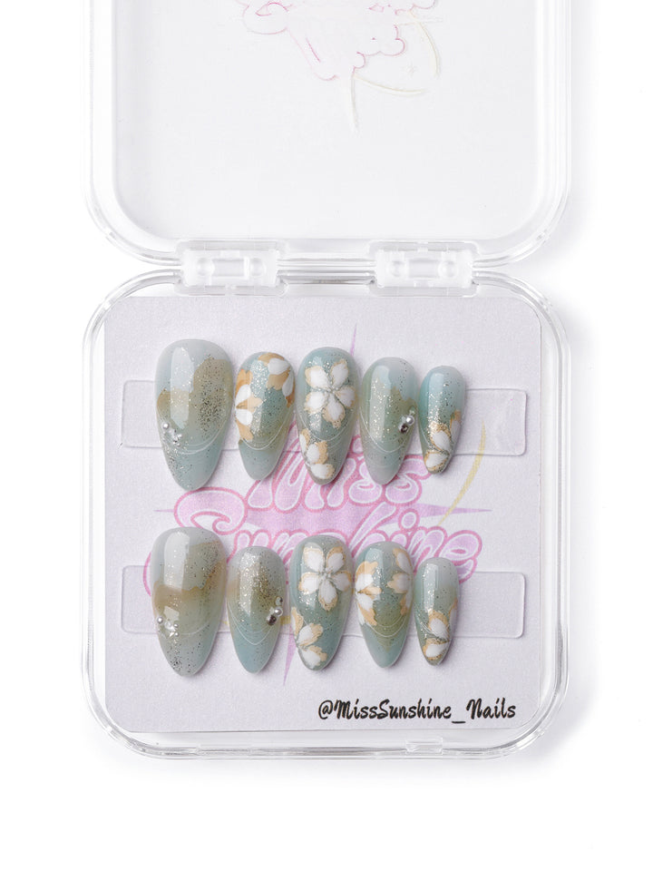 Nature-inspired press-on nails with moss green base and dewy flower designs in short almond shape.