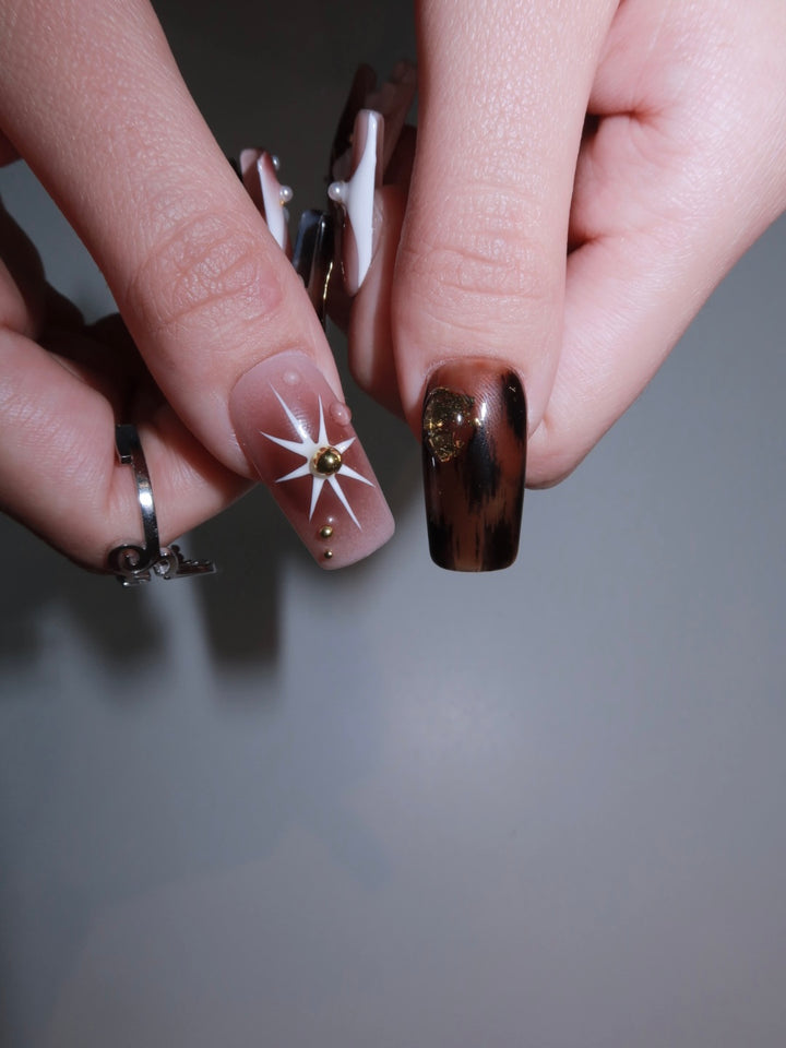 Elegant press-on nails featuring chocolate tones, jelly art, and vintage-inspired gold elements.
