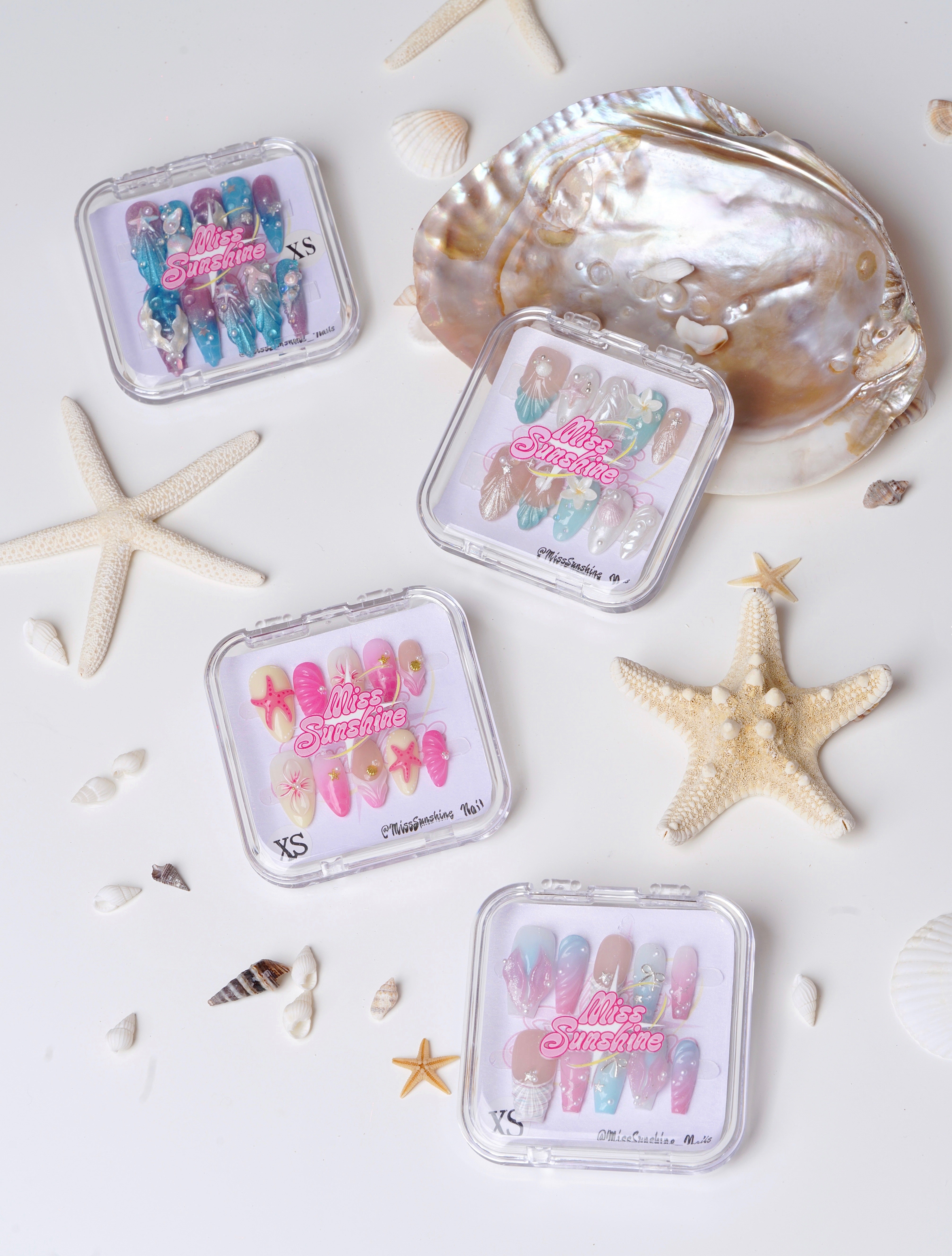 Colorful summer nails with seashells, starfish, pearls, flowers, and gradient pastel tones