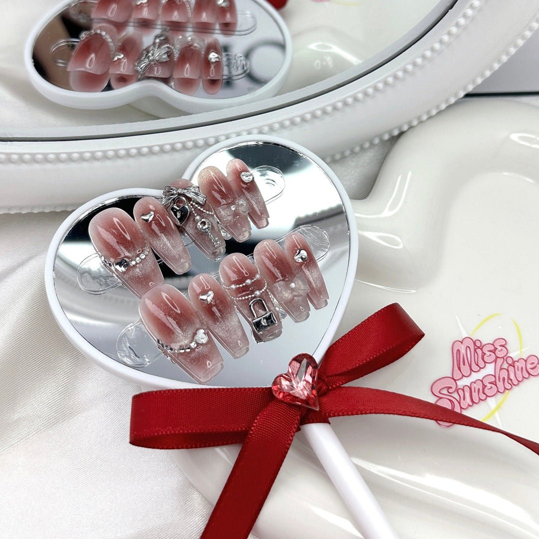Pink ombré nails with silver heart charms