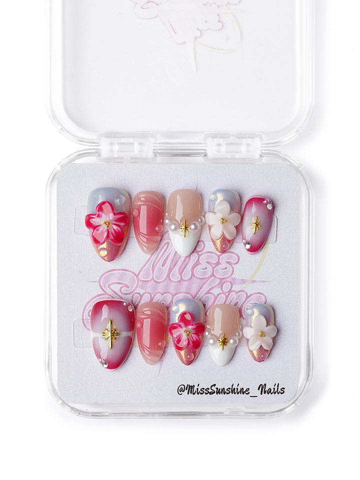 extra Short almond nails in pink hues with white flower embellishments and pearl details