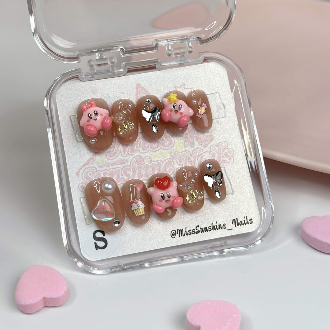 Nude nails with Kirby and cupcake charms