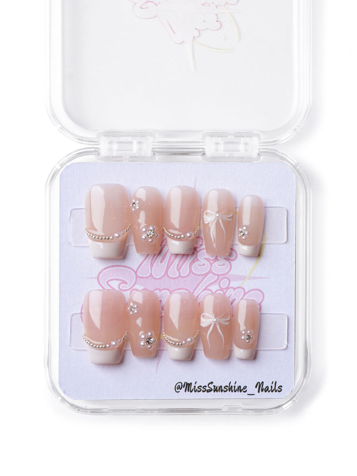 Nude and pearl-accented short coffin press-on nails with a minimalist yet sophisticated design.
