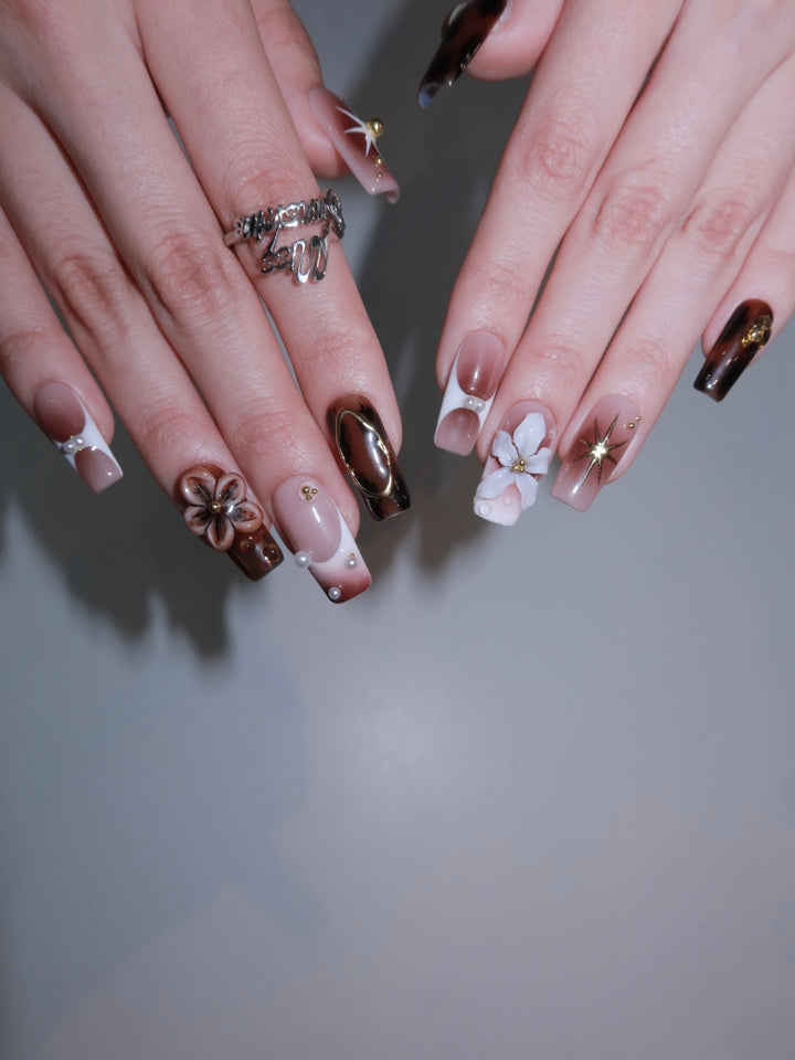 Medium square press-on nails with brown and nude contrast, complete with gold starburst and floral