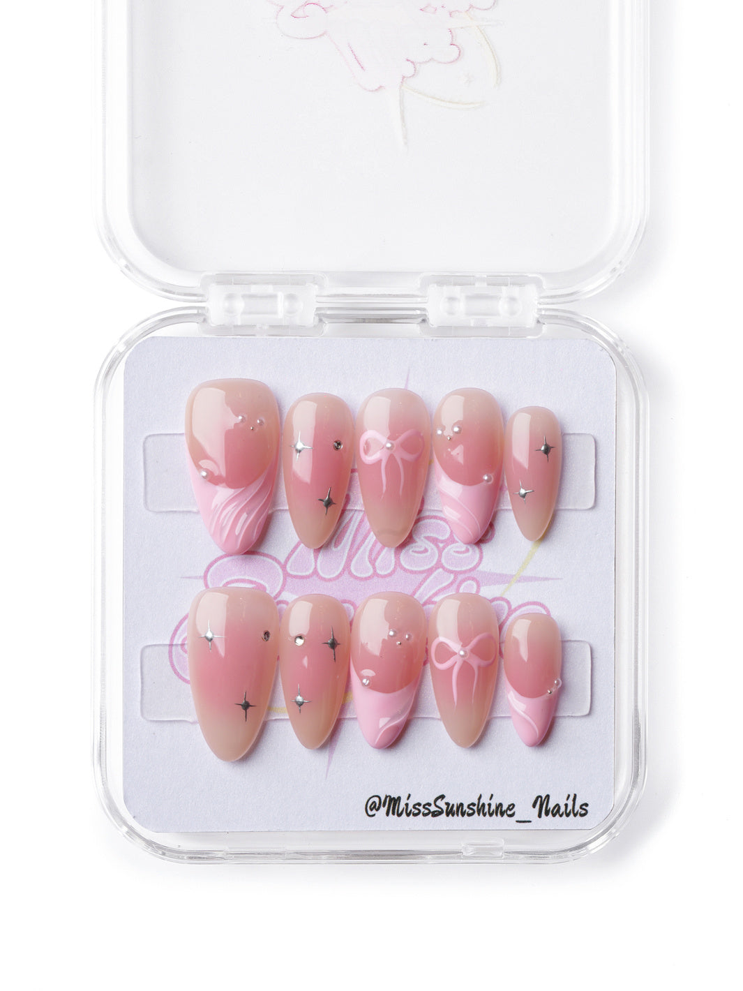 Elegant soft pink short almond press-on nails with dainty bows, shimmering accents, and a ballet-inspired ombré design.