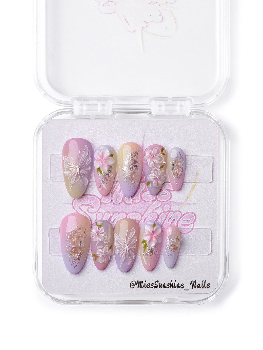 Handmade press-on nails in soft yellow, peach, and lilac tones with glitter and floral 3D art.