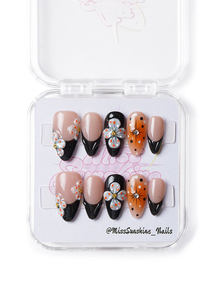 Handmade floral nails with orange accents, polka dots, and glossy gel finish