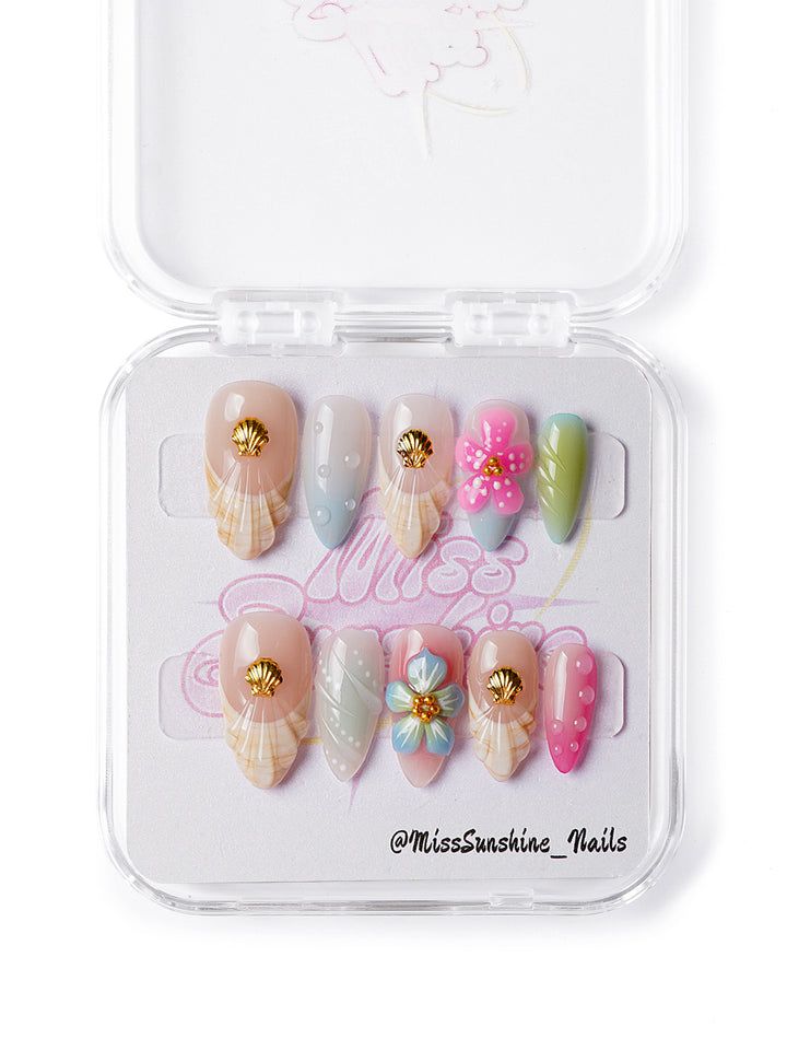 Handmade press-on nails featuring pink, nude, and green beach tones with summer-ready designs