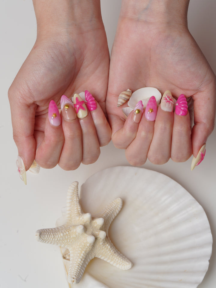 Short almond press-on nails with 3D pink starfish, seashell textures, and yellow-pink ombré gradient