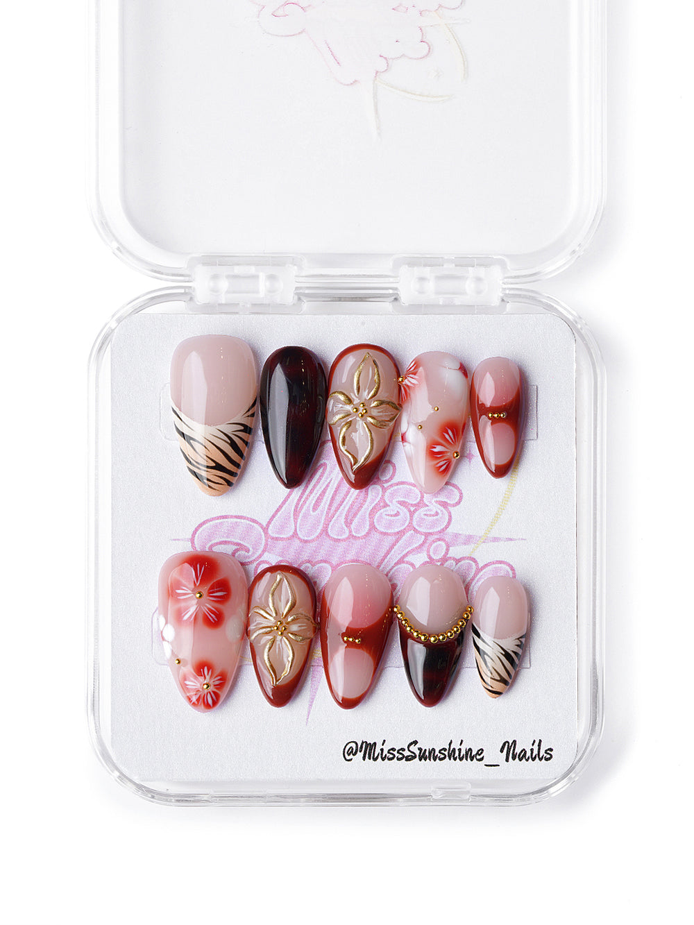 Handmade nail set featuring sculpted flowers, gold chain detailing, and earthy red gradient art
