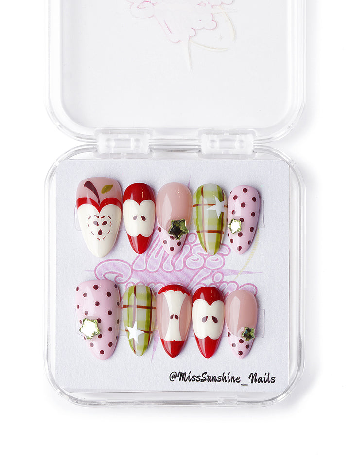 Hand-painted apple press-on nails with blush base, gingham print, and red fruit illustrations