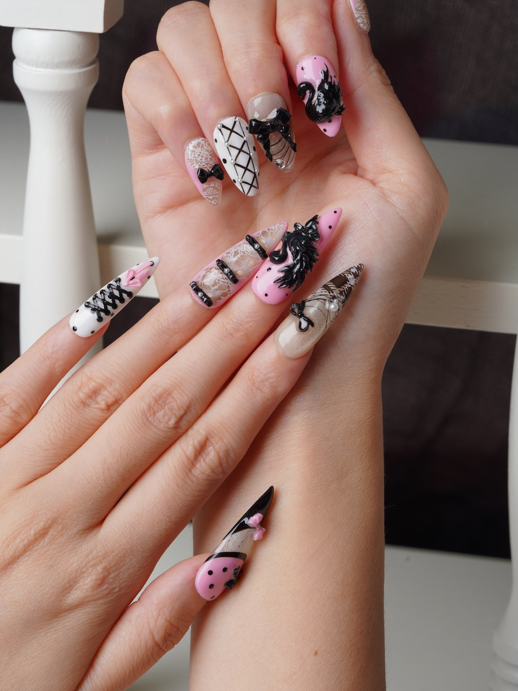 Elegant stiletto nails with 3D swan and delicate lace patterns