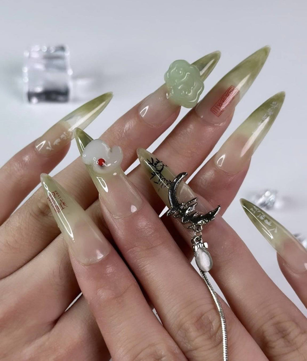 Jade green nails with silver moon and butterfly charms