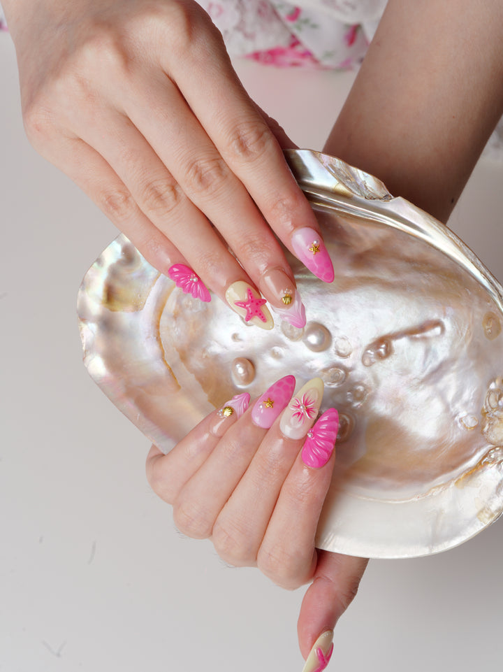 Handmade short almond nails with pastel ombré, 3D pink starfish, pearl accents, and seashell textures