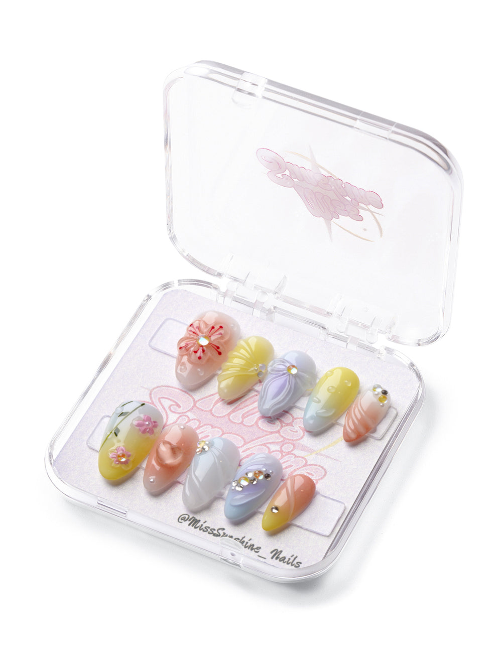  Blossom Parade short almond press-on nails with pastel gradients, 3D flowers, hearts, and gem accents.