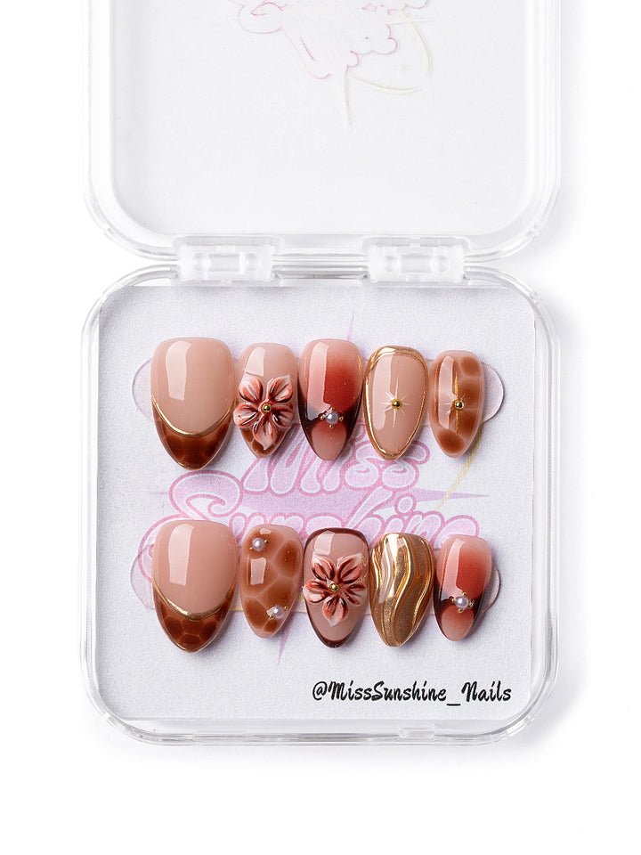 Handmade caramel and nude New Year nails with pearl and floral accents