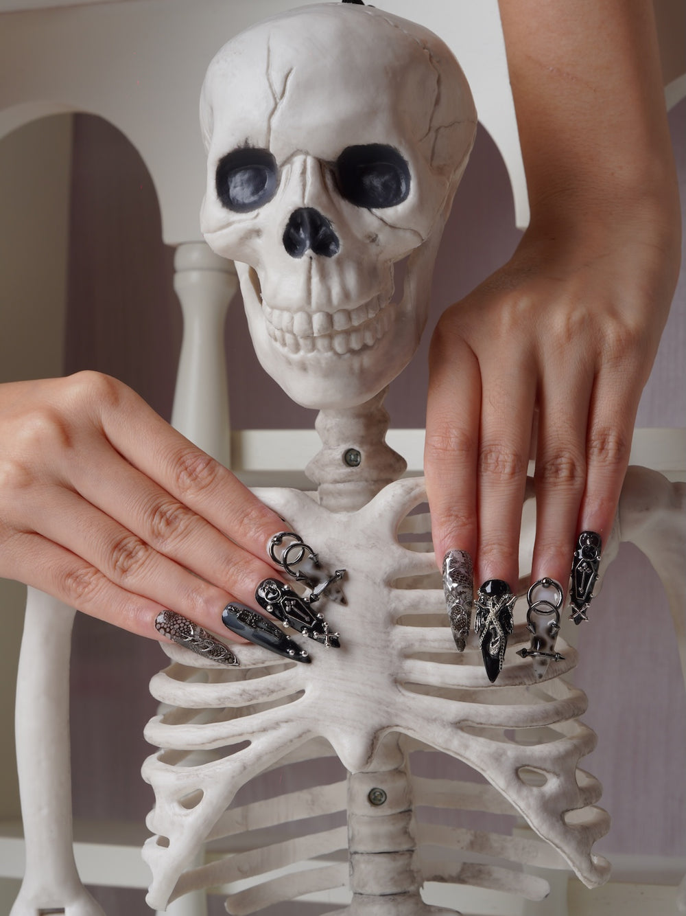 Chained Curse nails featuring metallic crosses and skeleton art