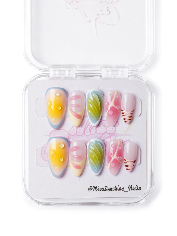 Handmade nails with abstract leaf patterns, yellow and pink gradients, and playful tropical designs