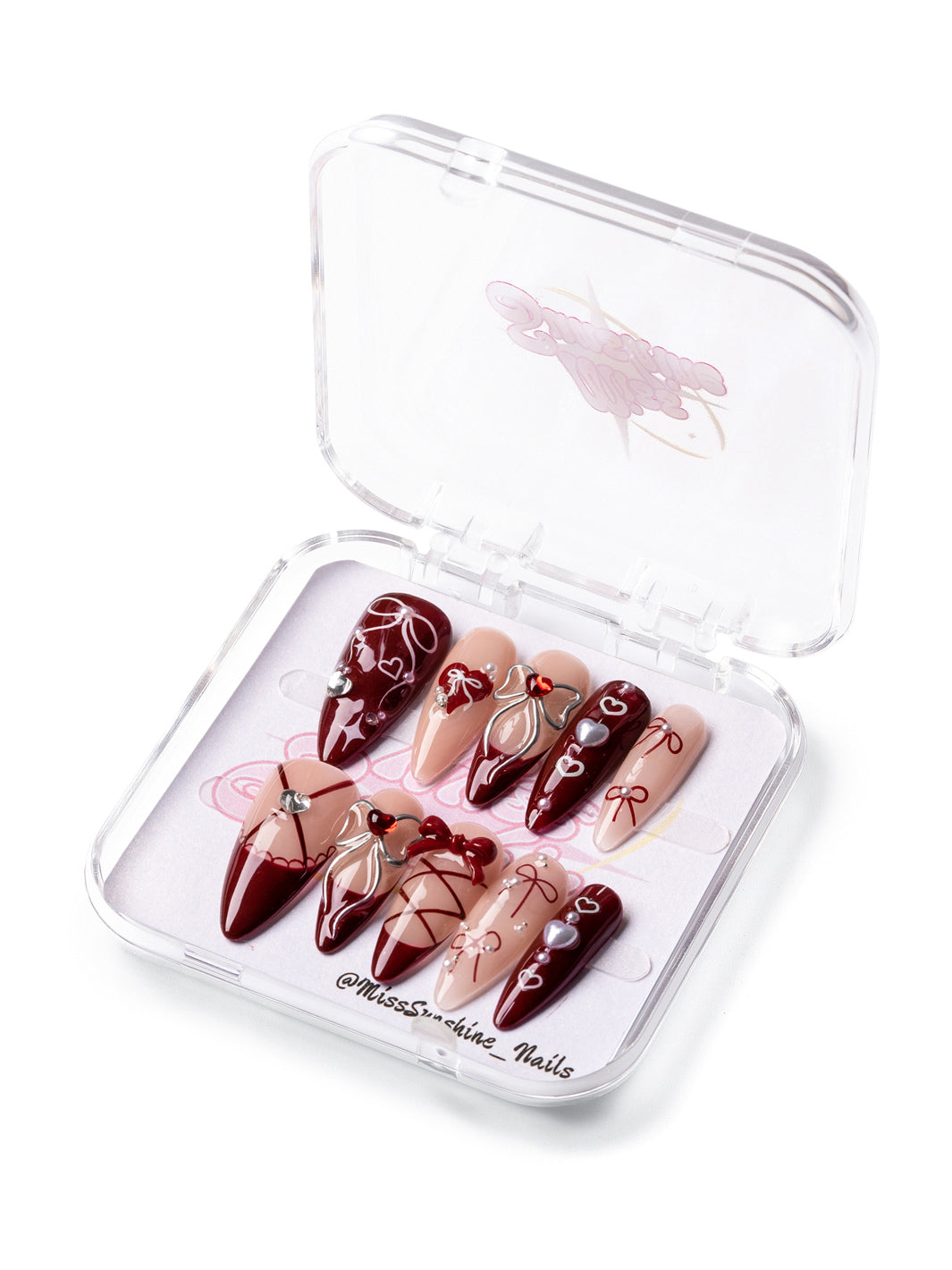 Dark Ballerina long almond press-on nails with burgundy tones, lace patterns, and bows for Valentine’s Day.