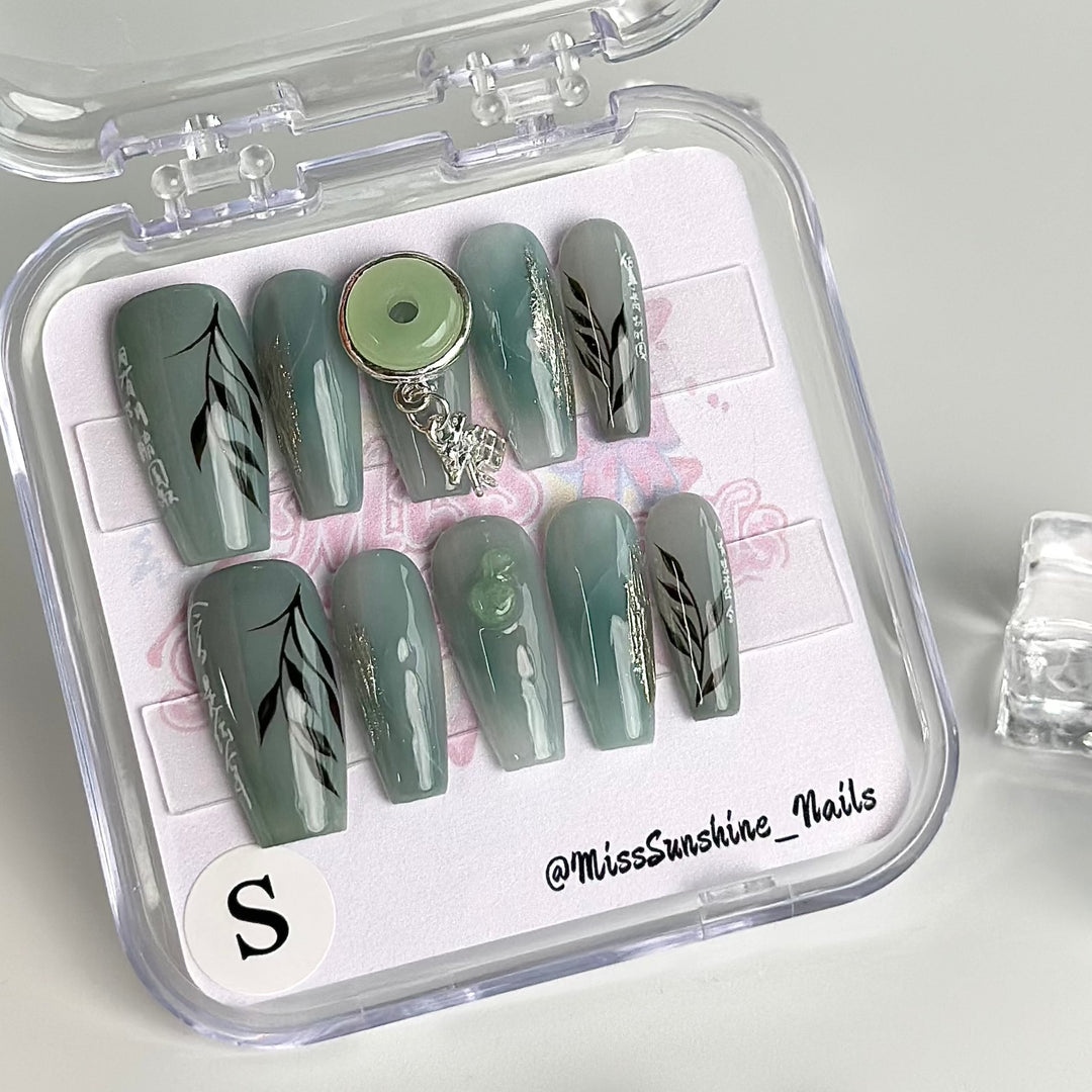 Sage green nails with gold linework accents