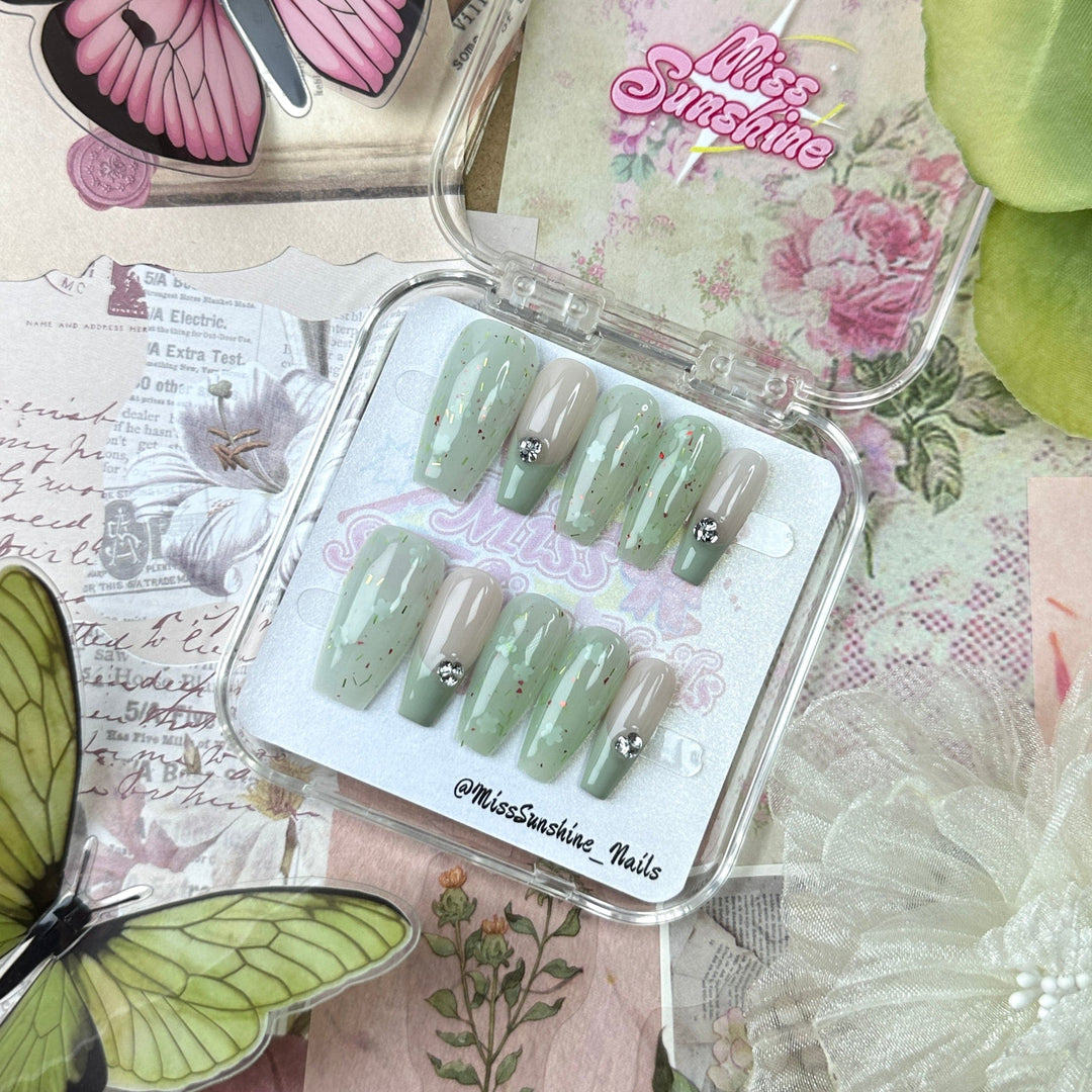 Sage green and nude coffin nails with crystal charms
