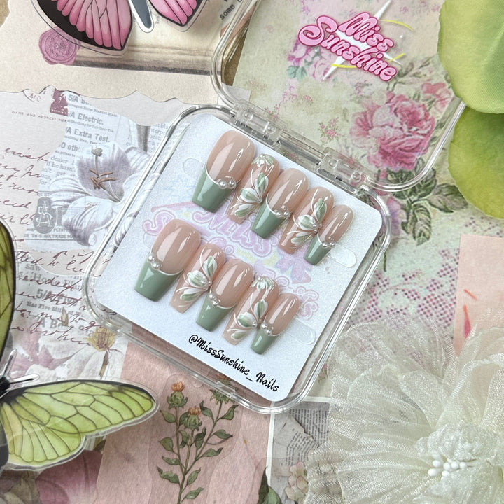 Hand-painted flower designs on soft green press-ons