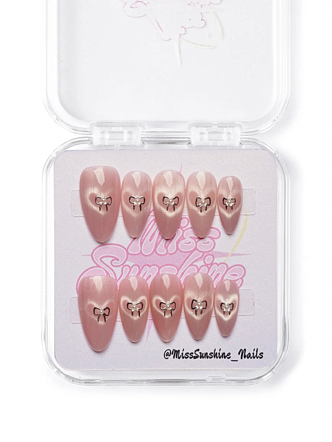 Short almond press-on nails in pearlescent pink with silver heart bow 