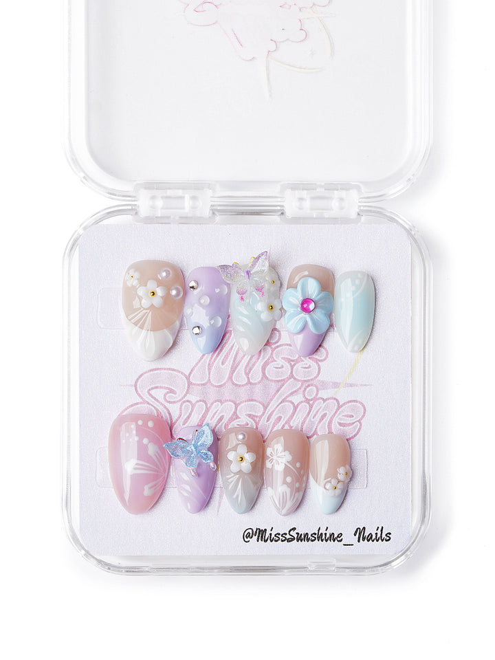 Handmade pastel press-on nails in extra short almond shape with butterflies, pearls, and spring florals