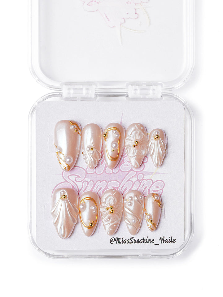 Handmade short almond nails with pearls, gold accents, and 3D sculptural textures