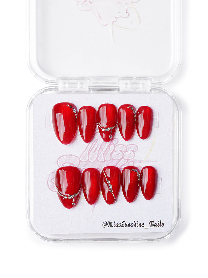 Handmade extra short almond nails with glossy red base and silver rhinestone chains