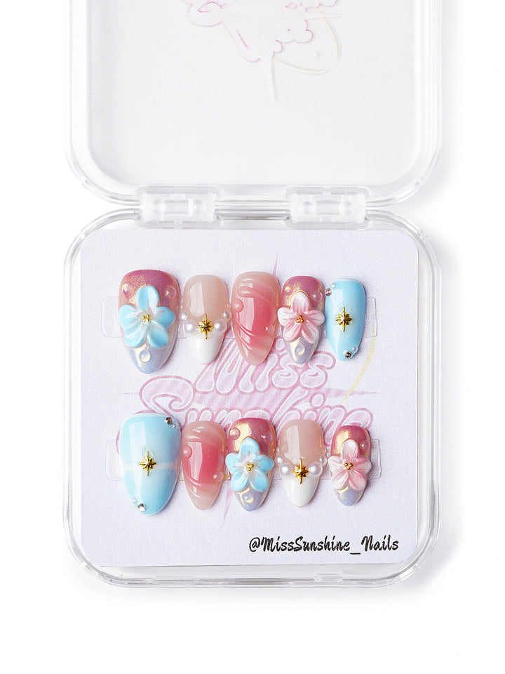 Handmade extra short almond nails with soft pastel swirls, 3D blossoms, pearl charms, and gold starburst details