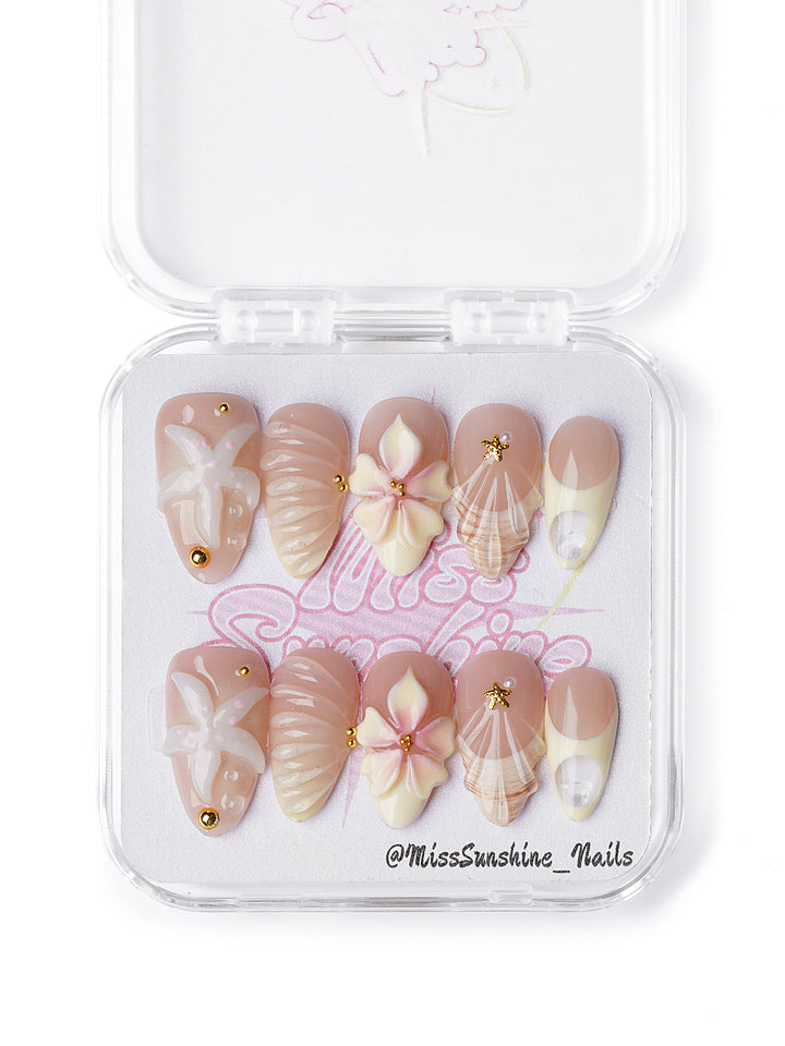 Creamy nude press-on nails with seashell textures and 3D flowers in short almond shape