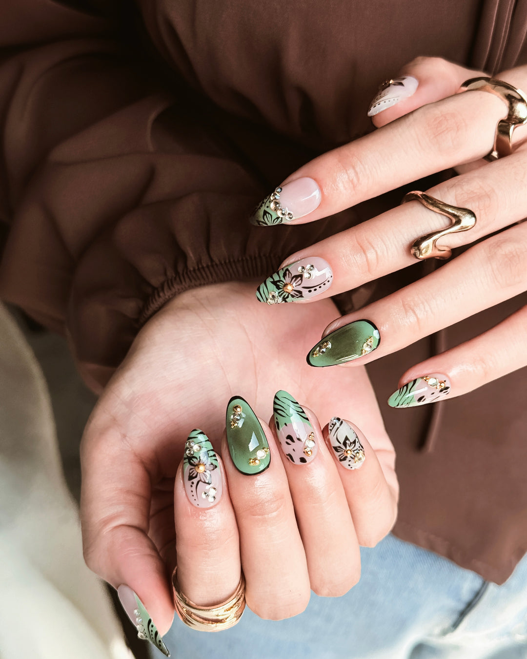 Olive Petal fall nail design with botanical details, rhinestones, and muted green accents