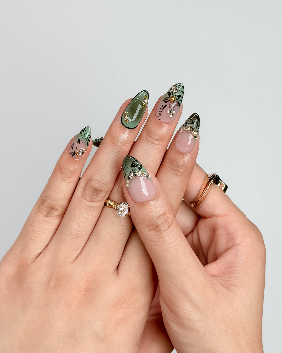 Olive Petal sage green floral press-on nails with blush nude base and gold rhinestone accents
