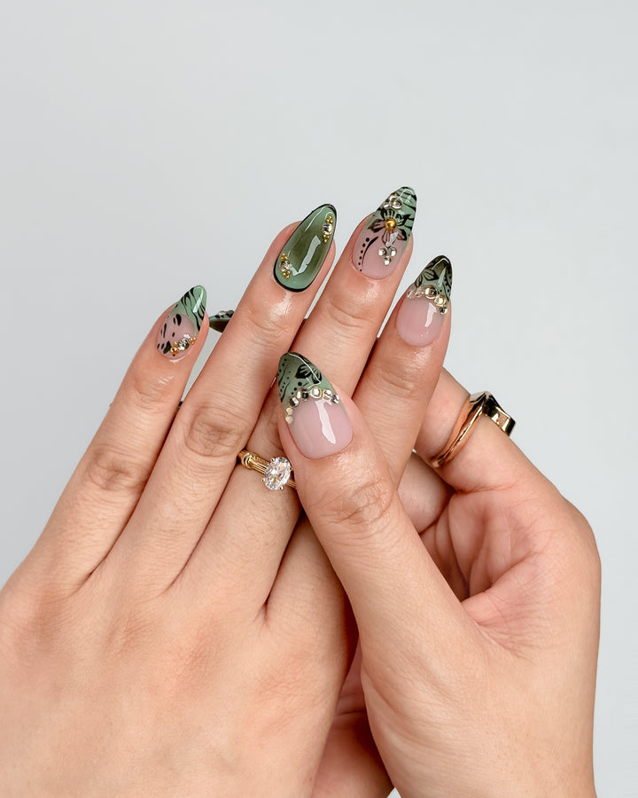 Olive Petal sage green floral press-on nails with blush nude base and gold rhinestone accents