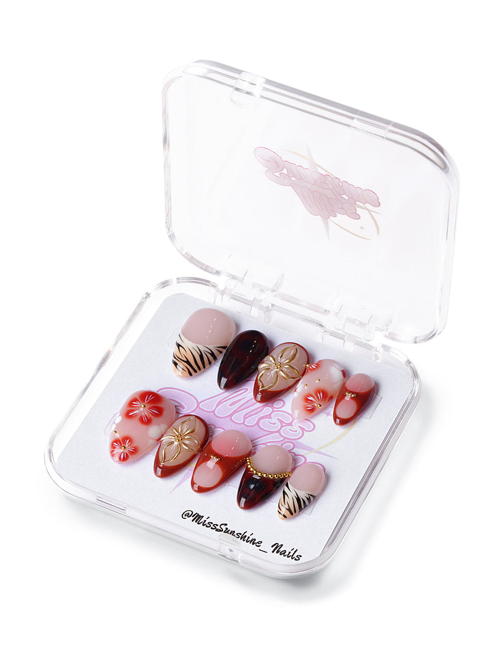 Short almond press-on nails in red and blush tones with gold ginkgo leaves, zebra print, and 3D floral accents