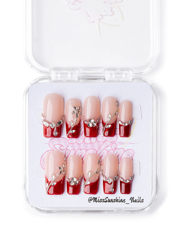 Medium square press-on nails with red glitter tips and rhinestones