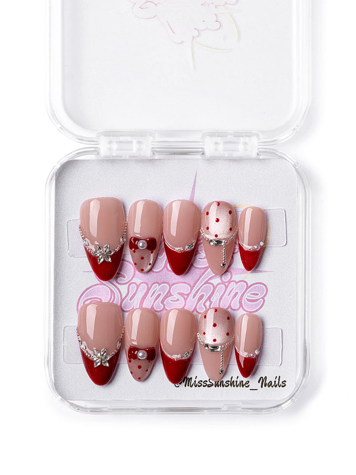 Red Lover nail set featuring polka dots, chains, and pearls