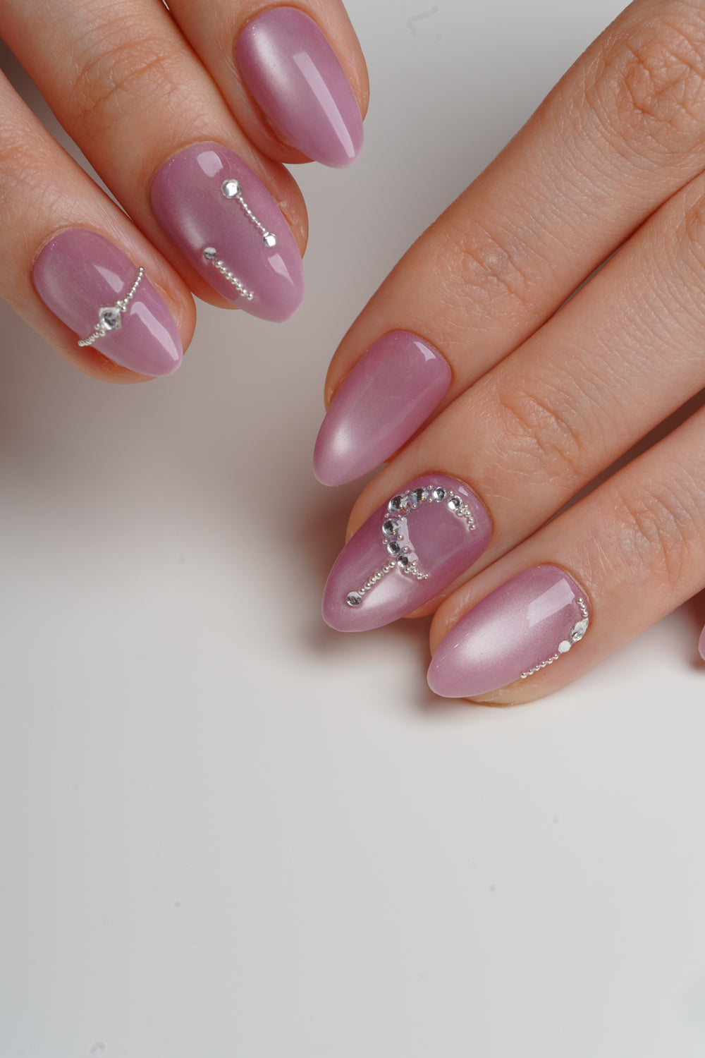 Pink magnetic shimmer graduation nails with crystal accents