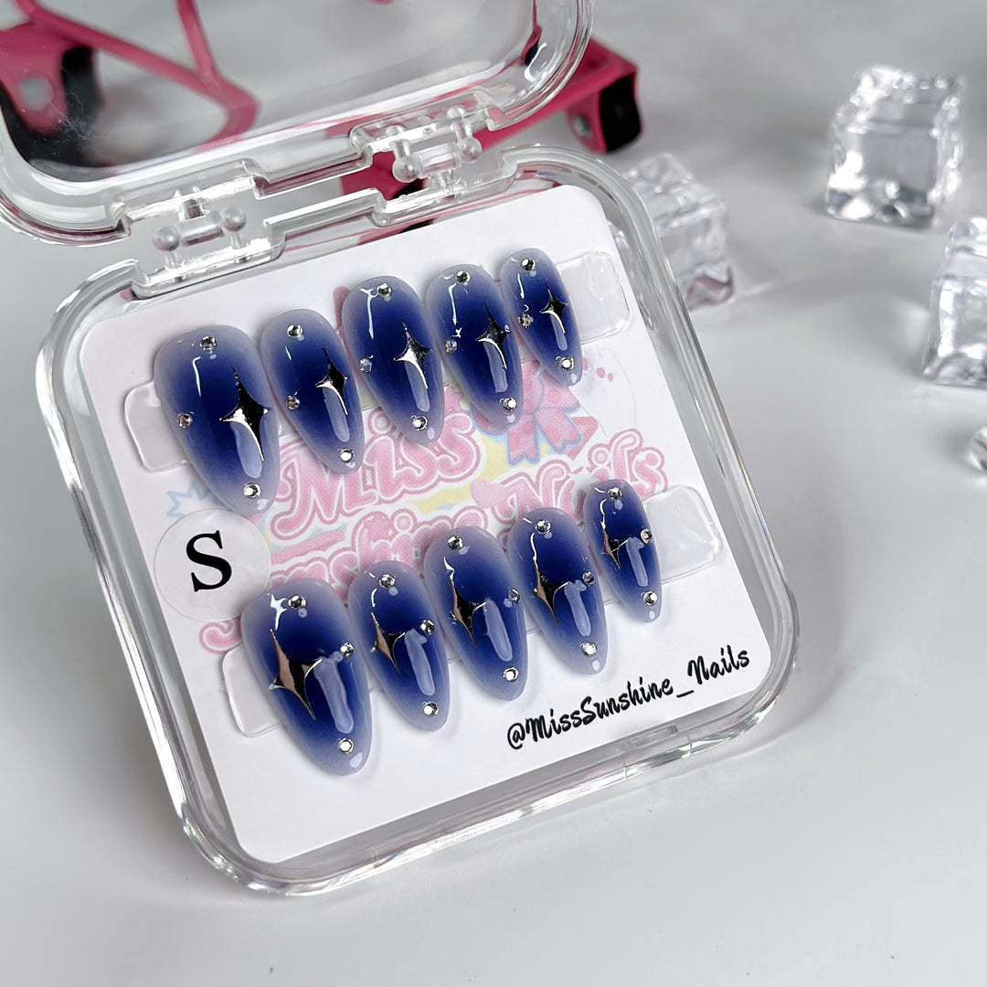 Handcrafted blue nails with celestial silver designs