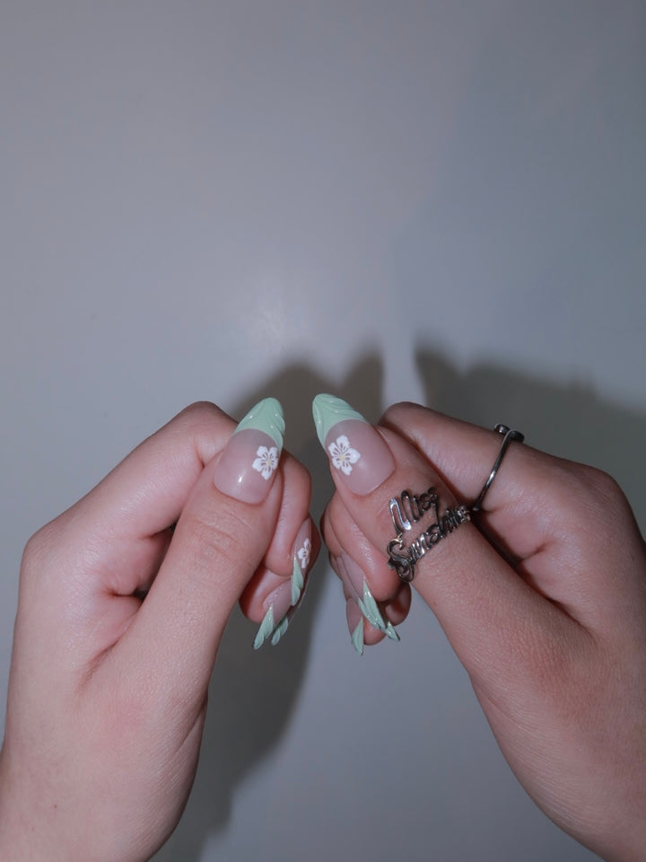 Nude nails featuring hand-painted daisy design