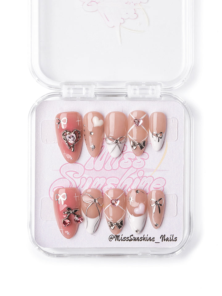 Short almond press-on nails with pink bows and heart designs