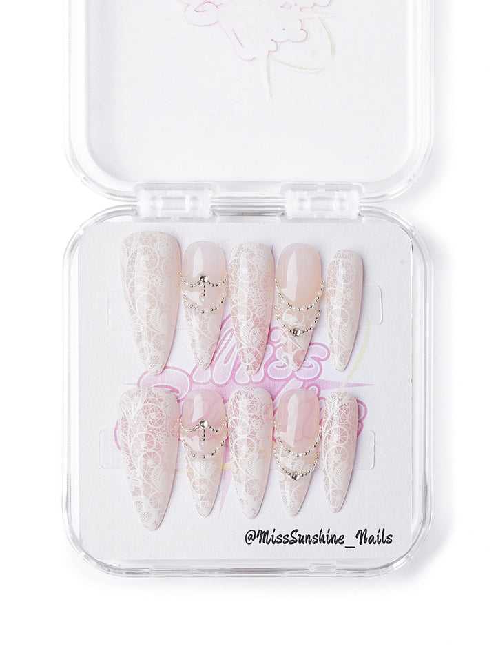 Handmade winter nail set featuring intricate lace overlays and rhinestone chain accents